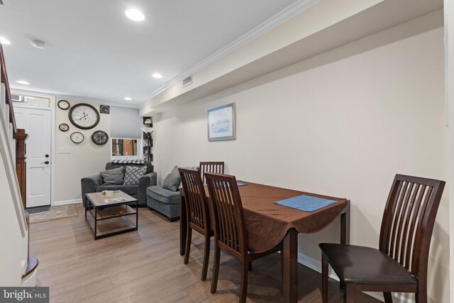 dining room featuring crown molding and light hardwood / wood-style flooring