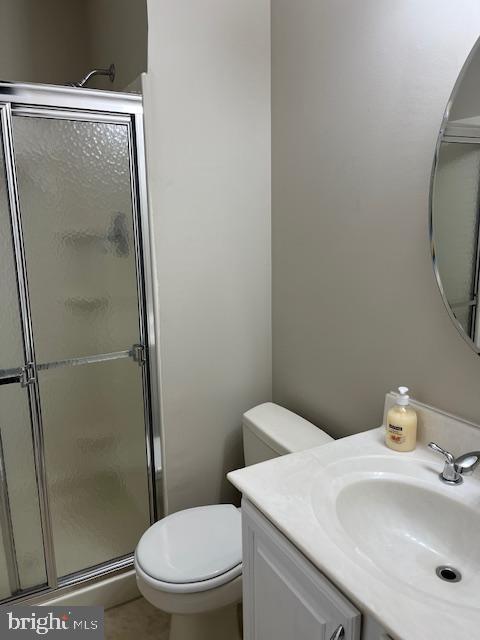 bathroom with walk in shower, tile patterned floors, vanity, and toilet