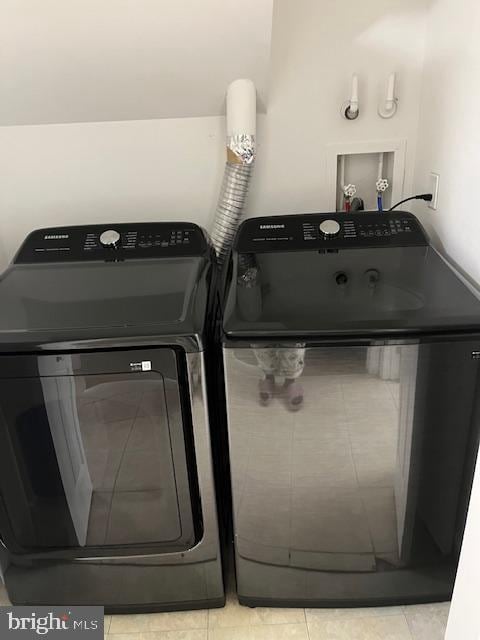 laundry area featuring light tile patterned floors and washer and dryer