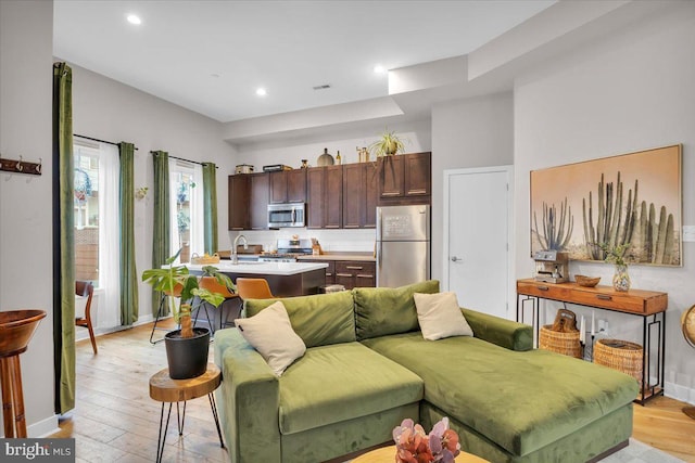 living room featuring light wood-type flooring and sink