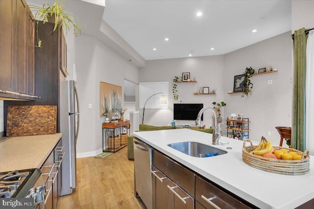 kitchen with sink, stainless steel appliances, light hardwood / wood-style flooring, and dark brown cabinets