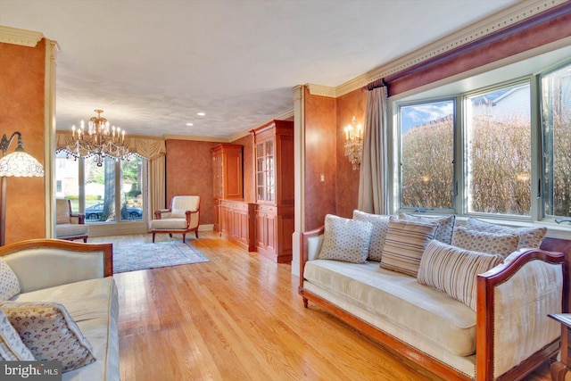 living room featuring a notable chandelier, light hardwood / wood-style flooring, and crown molding