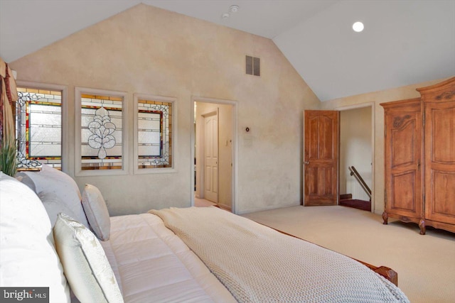 carpeted bedroom with high vaulted ceiling