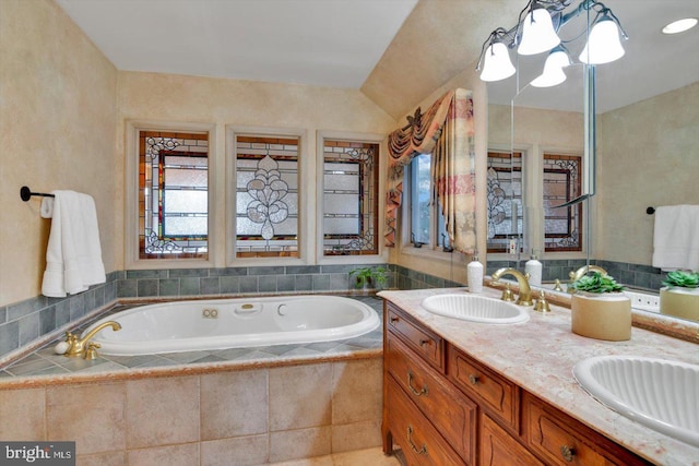 bathroom with vanity and tiled tub