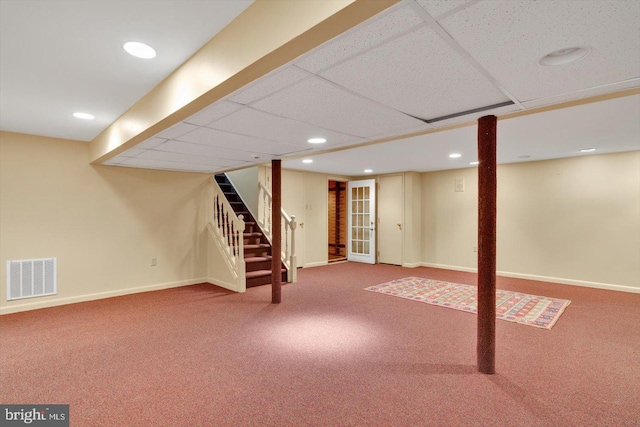 basement with a paneled ceiling and carpet floors