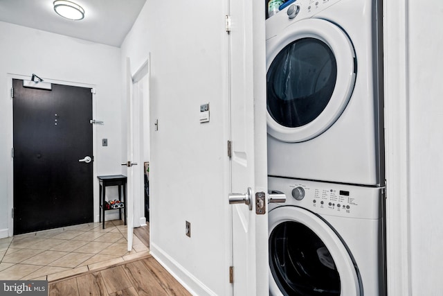 clothes washing area featuring stacked washer and clothes dryer and light tile patterned flooring