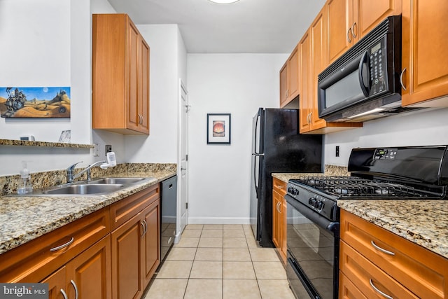 kitchen featuring light tile patterned floors, sink, light stone counters, and black appliances