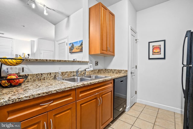 kitchen featuring black appliances, light stone counters, light tile patterned floors, and sink