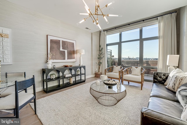 living room with light hardwood / wood-style flooring and an inviting chandelier