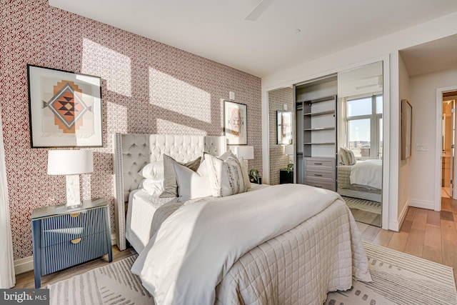 bedroom featuring ceiling fan, light hardwood / wood-style floors, and a closet