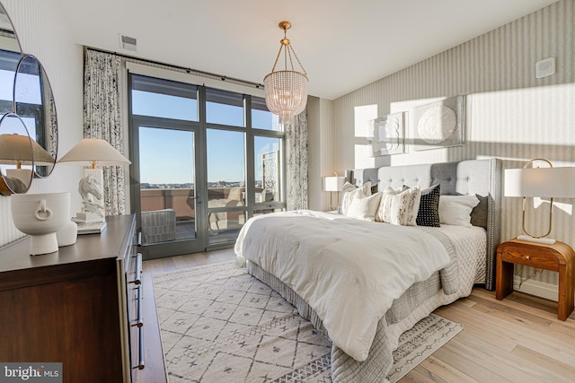 bedroom with light wood-type flooring and a notable chandelier