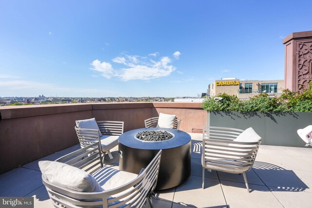 view of patio with an outdoor living space with a fire pit