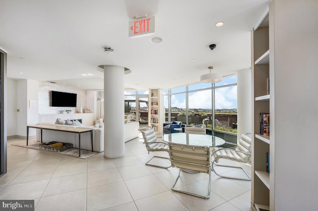 tiled dining space featuring built in features and a wall of windows