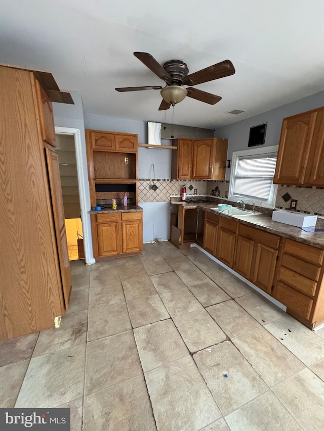 kitchen featuring decorative backsplash, ceiling fan, and sink