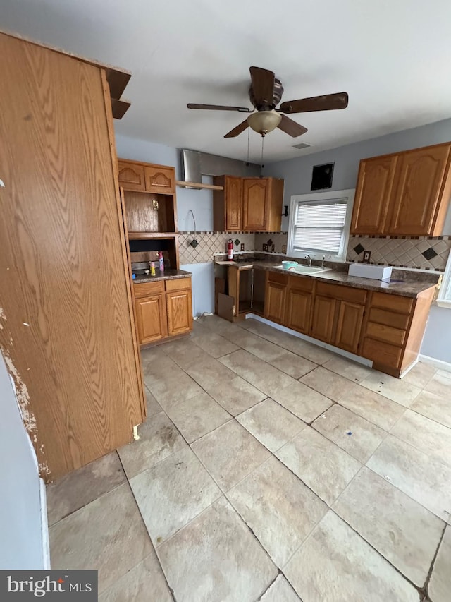 kitchen featuring ceiling fan, sink, and backsplash