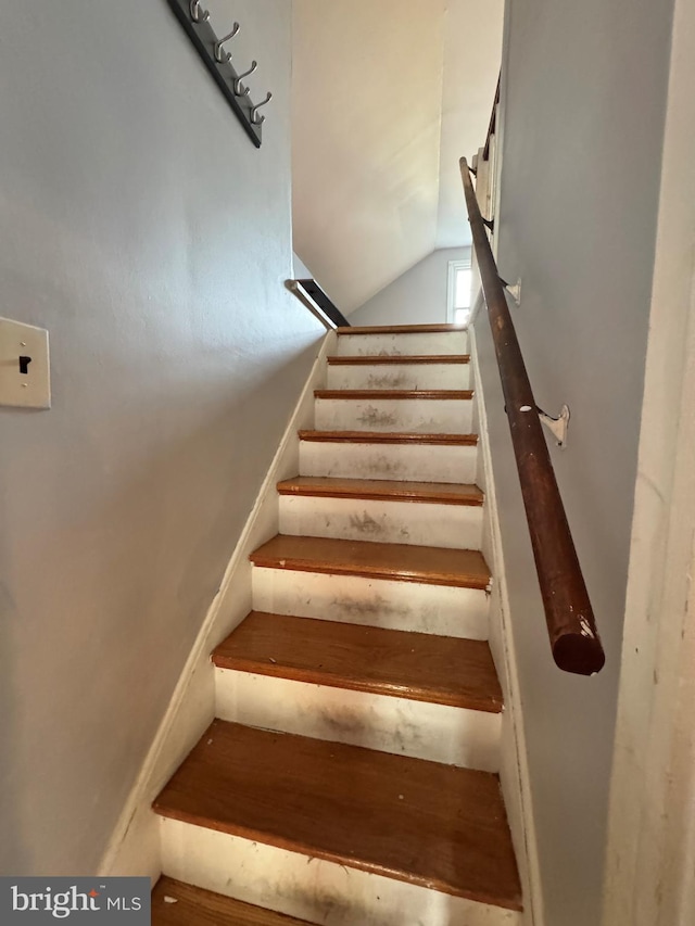 stairway featuring vaulted ceiling