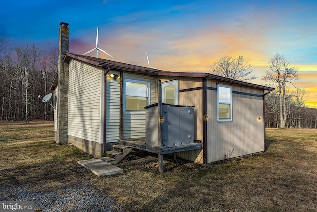 property exterior at dusk with a yard