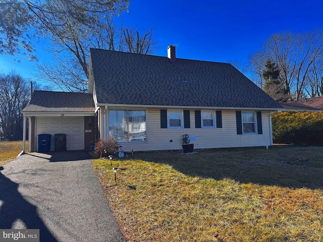 view of front of house with driveway, a shingled roof, a chimney, an attached garage, and a front yard