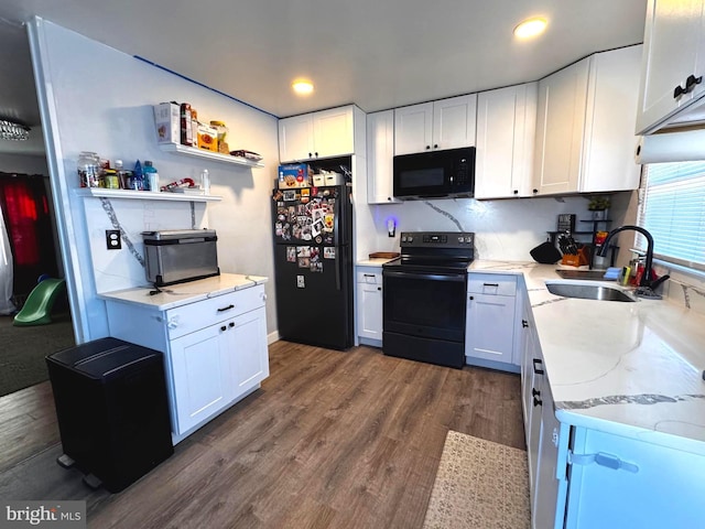 kitchen with light stone counters, a sink, white cabinetry, dark wood-style floors, and black appliances