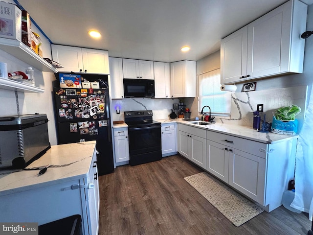 kitchen with dark wood-style flooring, a sink, white cabinets, light stone countertops, and black appliances