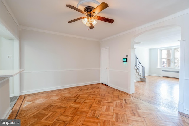 empty room with radiator, ornamental molding, light parquet floors, and ceiling fan