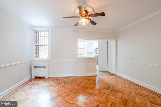 empty room featuring radiator heating unit, sink, ornamental molding, ceiling fan, and light parquet flooring