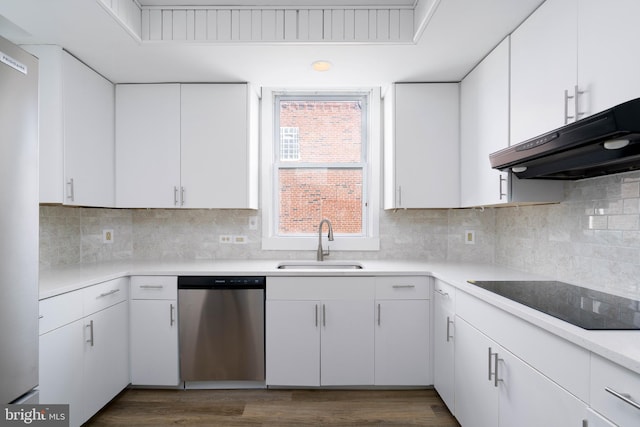 kitchen featuring appliances with stainless steel finishes, range hood, white cabinetry, sink, and decorative backsplash