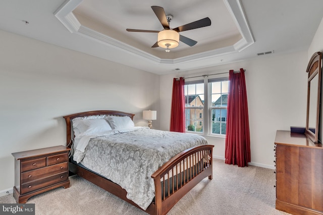 carpeted bedroom with a tray ceiling and ceiling fan