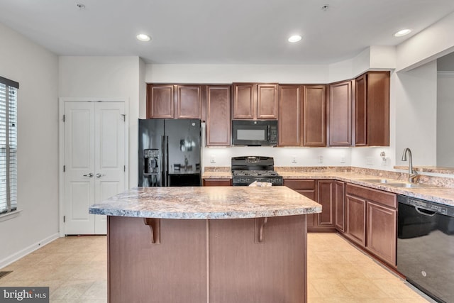 kitchen featuring a breakfast bar, sink, a kitchen island, and black appliances