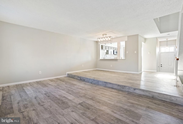 empty room with wood-type flooring and a textured ceiling