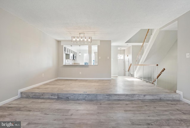 foyer with sink, light hardwood / wood-style floors, and a textured ceiling