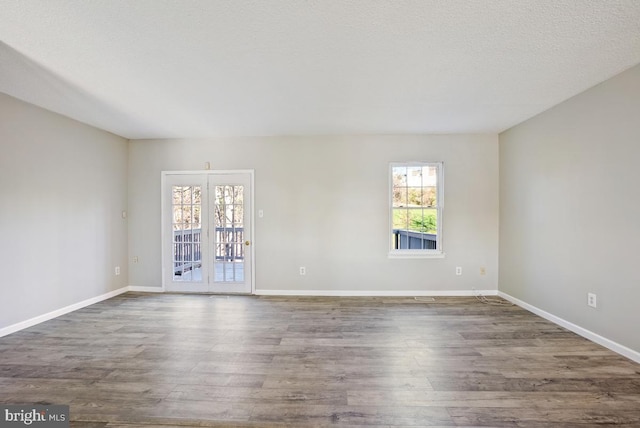 spare room featuring a textured ceiling and dark hardwood / wood-style flooring