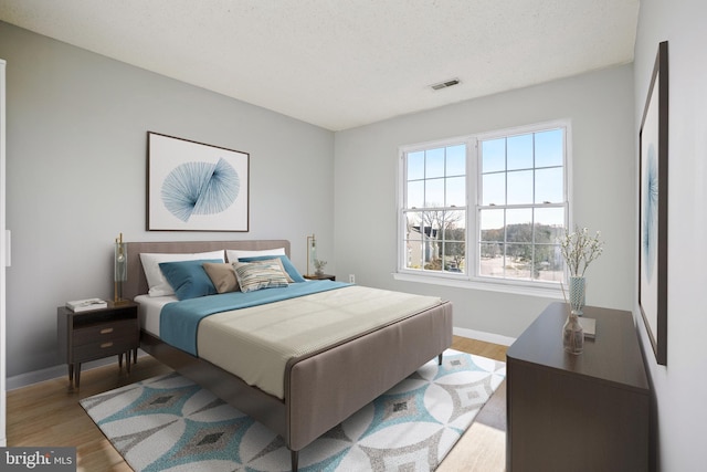 bedroom with hardwood / wood-style flooring and a textured ceiling