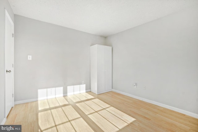 empty room featuring wood-type flooring and a textured ceiling