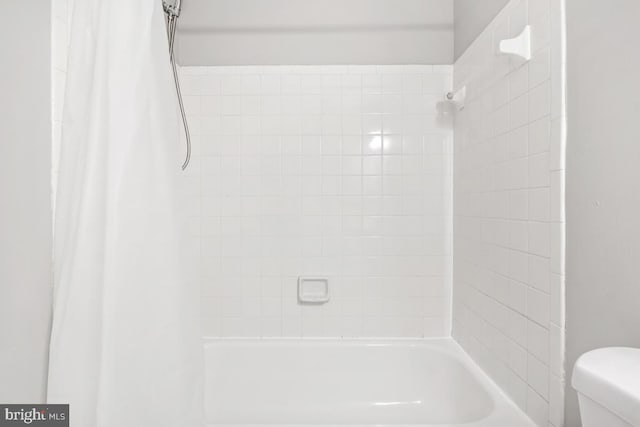 bathroom with shower / bath combo and toilet