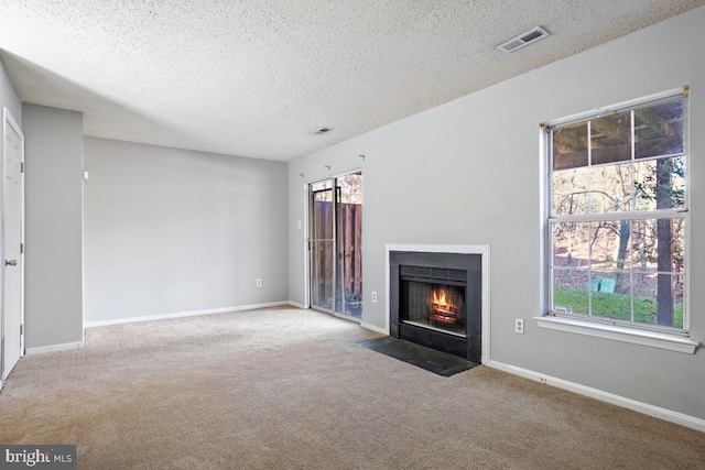 unfurnished living room with carpet flooring and a textured ceiling