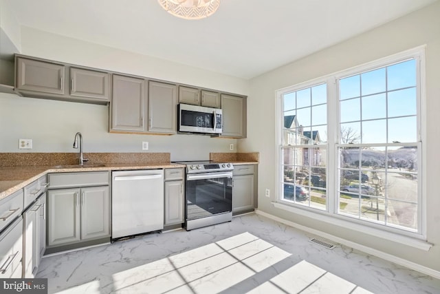 kitchen featuring gray cabinets, sink, and stainless steel appliances