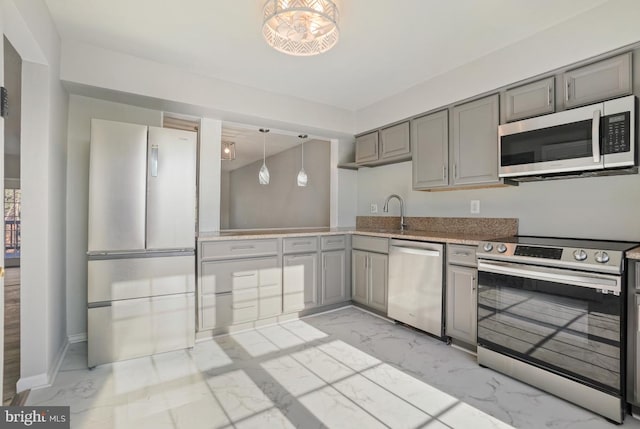 kitchen with pendant lighting, gray cabinets, sink, and stainless steel appliances