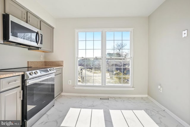 kitchen with electric range oven and gray cabinetry