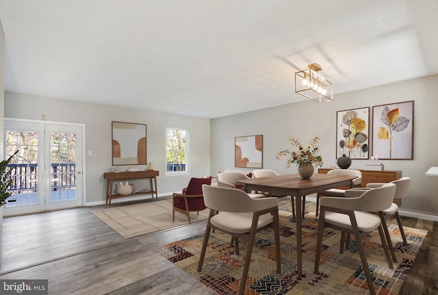 dining area with hardwood / wood-style flooring, a notable chandelier, and a textured ceiling