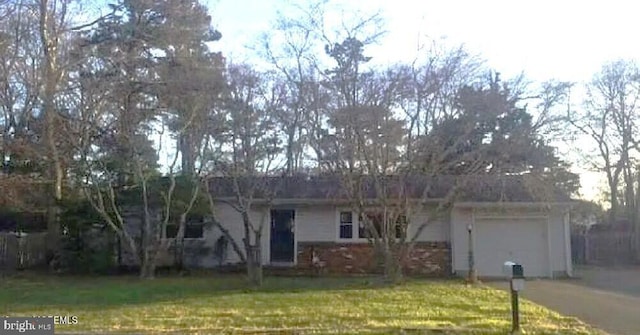 single story home featuring a front lawn and a garage