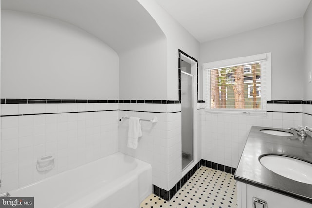 bathroom featuring tile patterned floors, vanity, tile walls, and shower with separate bathtub