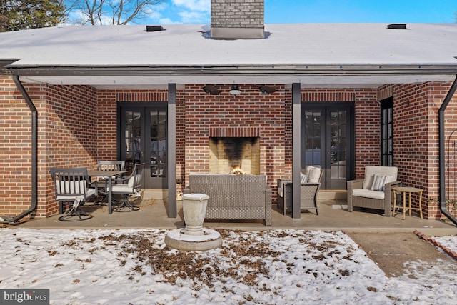 snow covered property with a patio area and french doors