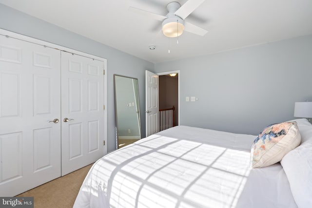 bedroom with light carpet, ceiling fan, and a closet