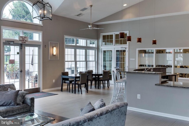 living room featuring hardwood / wood-style floors, high vaulted ceiling, and french doors