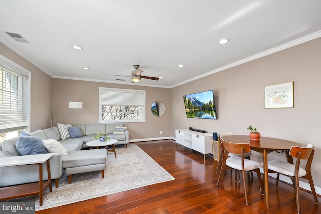 living room with dark hardwood / wood-style flooring, plenty of natural light, ornamental molding, and ceiling fan