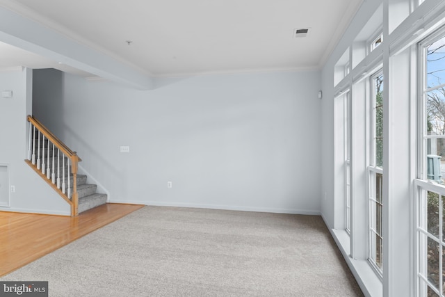 carpeted spare room featuring crown molding