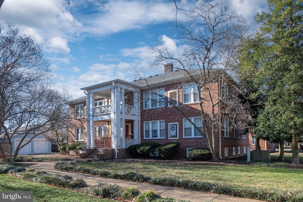 view of front of home featuring a balcony and a front lawn