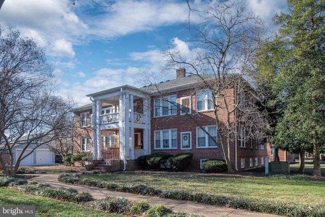 view of front of home featuring a balcony and a front lawn