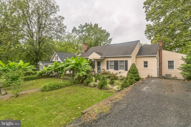 view of front of home with a front lawn and central air condition unit